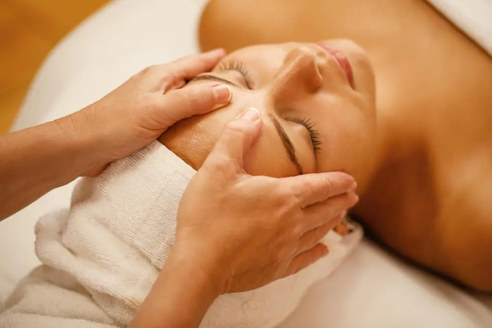 Mulher recebendo sessão de drenagem linfática facial em Joinville.